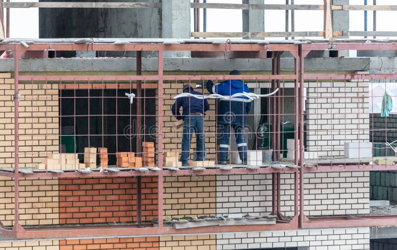 Workers Lay Brick Walls at the Construction Site of a Multistorey