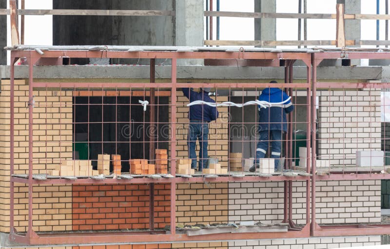 Workers Lay Brick Walls at the Construction Site of a Multistorey