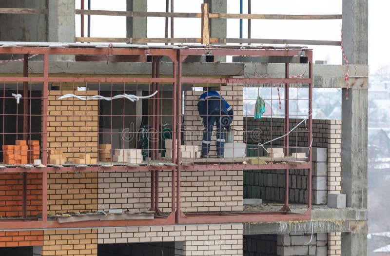 Workers Lay Brick Walls at the Construction Site of a Multistorey Building. Stock Image Image