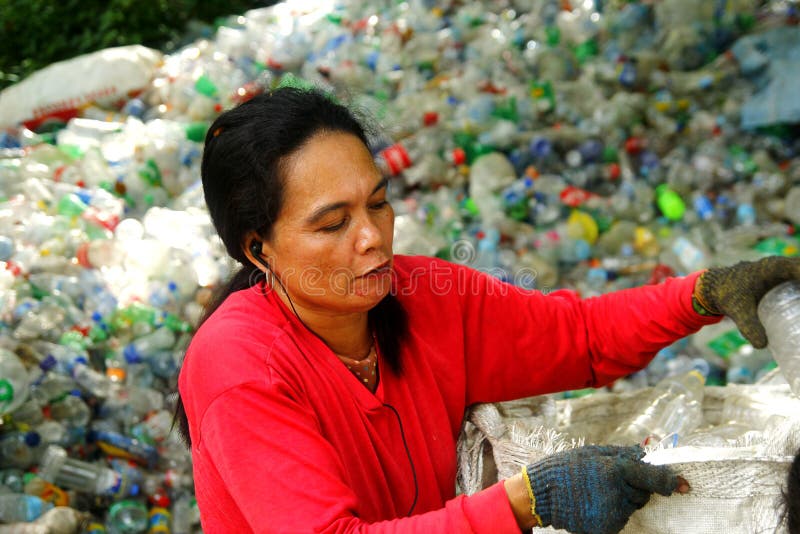 Workers of a materials recovery facility sort through plastic waste and segregate them for proper recycling