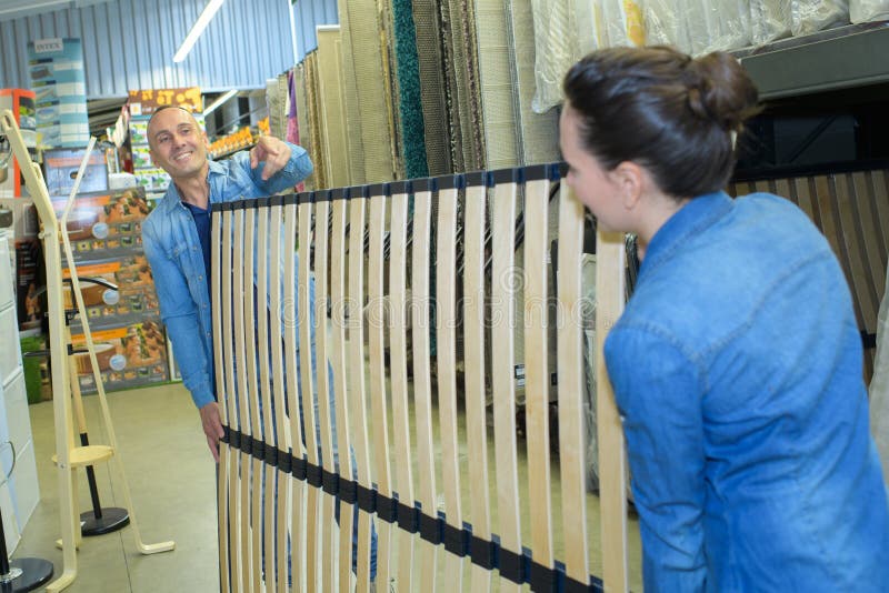 Workers moving bed frame with slat base