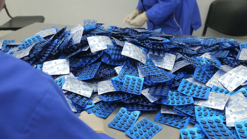 The workers of the pharmaceutical factory sort of blisters stock footage