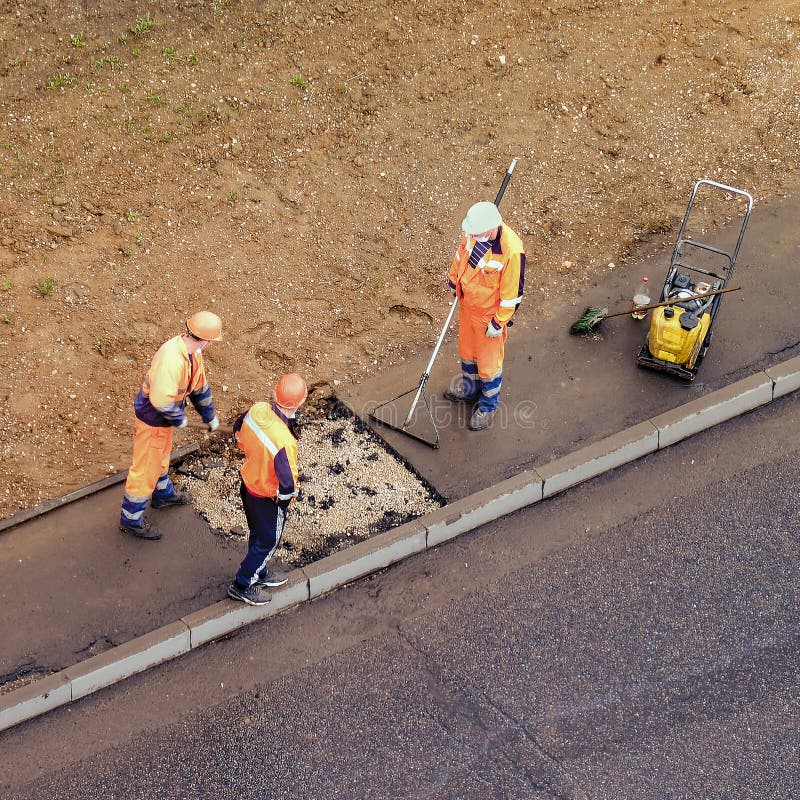 Workers Plug a Hole in the Sidewalk Removing the Old Asphalt To Install