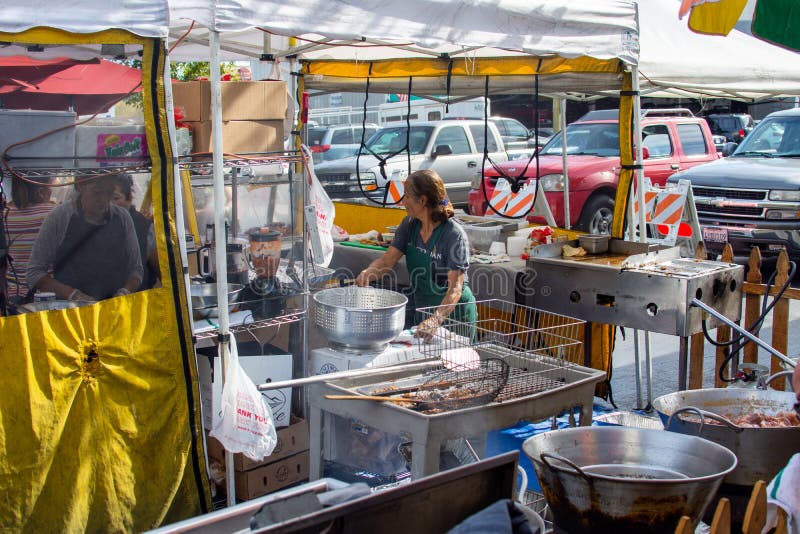 Workers prepare carnitas and pork cheek at a taco stand at the Canoga Park Farmer`s Market on Owensmouth Ave. royalty free stock photos Workers prepare carnitas and pork cheek at a taco stand at the Canoga Park Farmer`s Market on Owensmouth Ave. royalty free stock photos