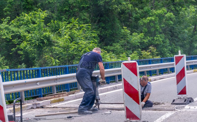 Workers restore the road near the monastery of Moraca. stock image Workers restore the road near the monastery of Moraca. stock image