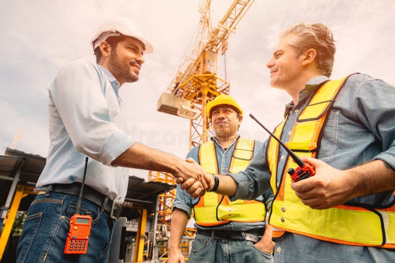 Workers team hand shaking deal with contractor happy at construction site. Engineer project business contact connection people royalty free stock image