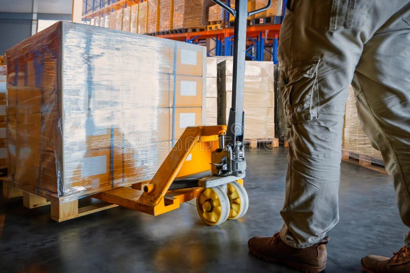 Workers Unloading Package Boxes on Pallets in Storage Warehouse