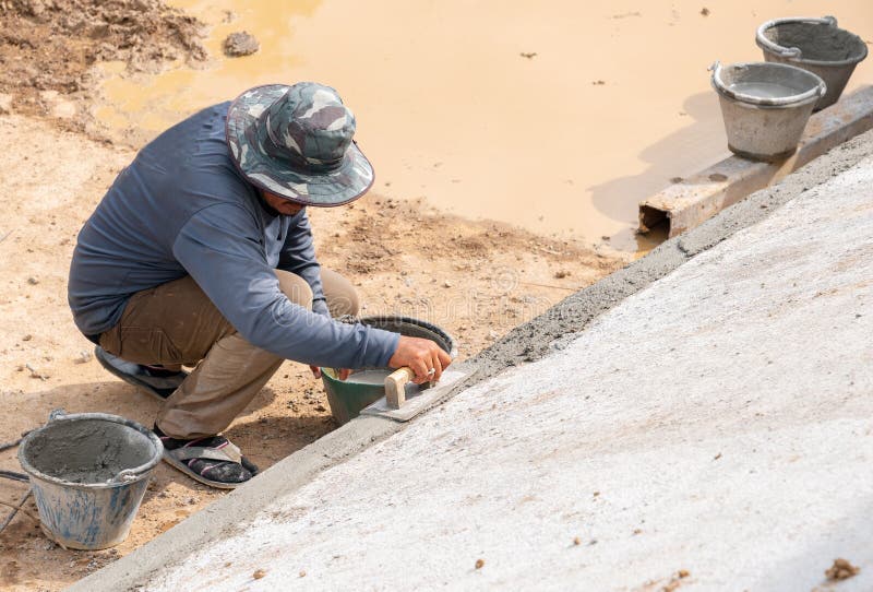 Workers Use Trowel Plastering on the Edge of the Pool Stock Image