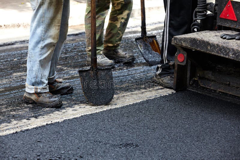 Workers Using Asphalt Paver Tools during Road Construction. Stock Image