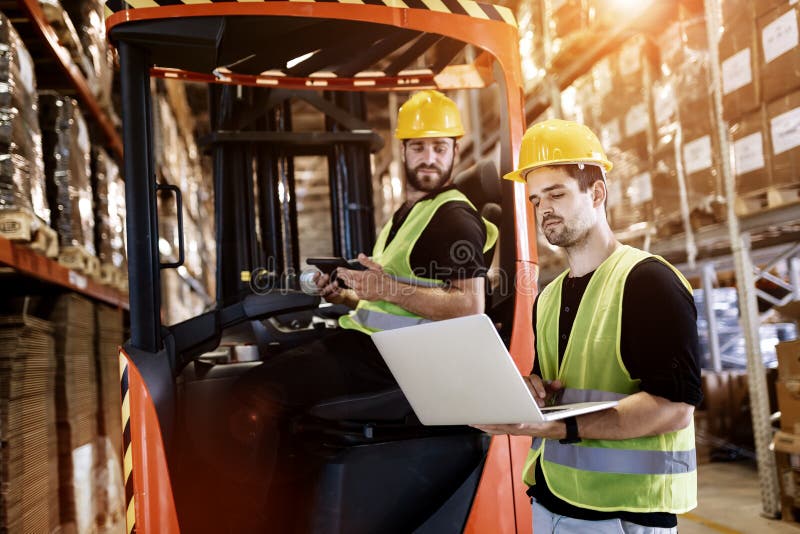 Workers using technology forklift in warehouse stock photography