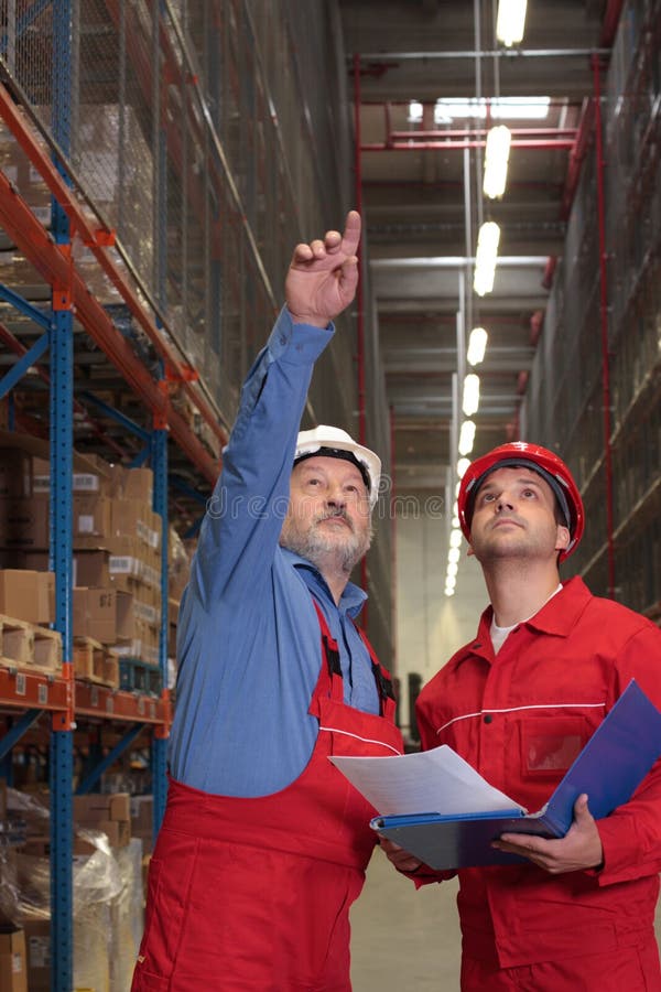 Two workers in uniforms in warehouse. one is older, one is younger,different activities. Architect uniform stock images, royalty-free photos and pictures