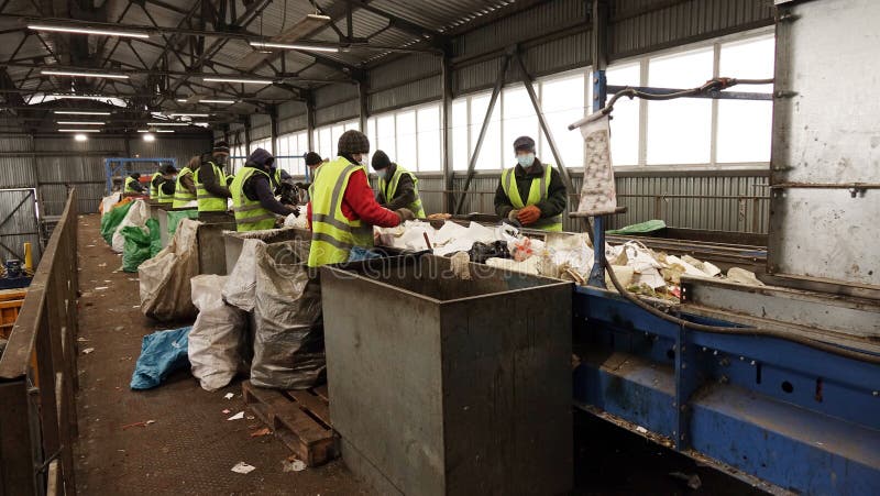 Workers at the waste processing plant. Sorting trash on a conveyor belt royalty free stock photos Workers at the waste processing plant. Sorting trash on a conveyor belt royalty free stock photos