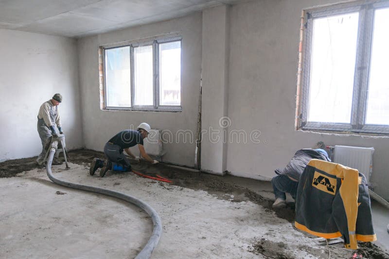 Workers in Work Clothes are Doing Their Job, Leveling the Floor and