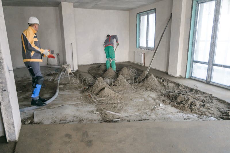 Workers in Work Clothes are Doing Their Job, Leveling the Floor and