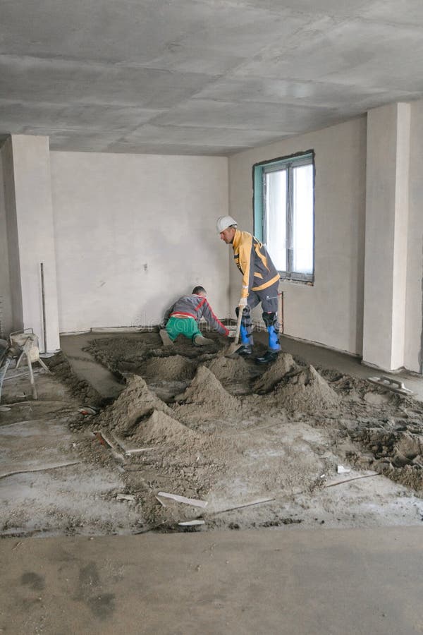 Workers in Work Clothes are Doing Their Job, Leveling the Floor and