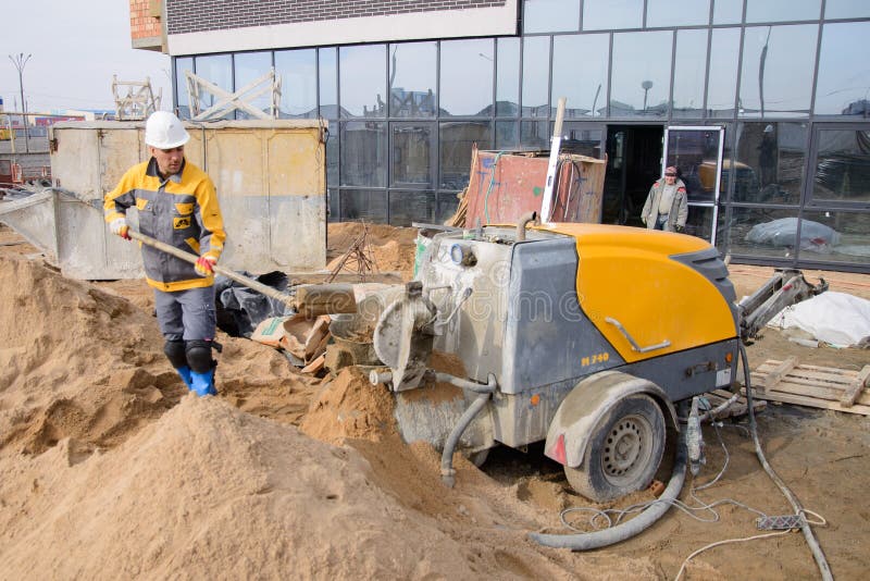 Workers in Work Clothes are Doing Their Job, Leveling the Floor and