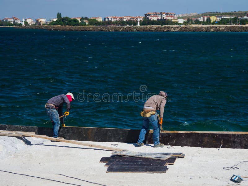 Canakkale, Turkey - October 05, 2018: Unidentified workers working at the harbour for a ferry crossing Dardanelles Strait in Canakkale, Turkey. Canakkale, Turkey - October 05, 2018: Unidentified workers working at the harbour for a ferry crossing Dardanelles Strait in Canakkale, Turkey