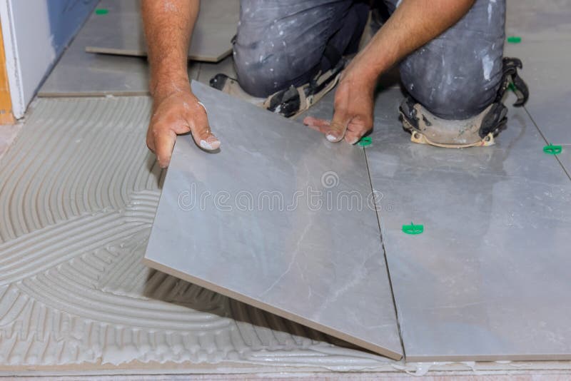 Working on an Adhesive Surface while Installing Ceramic Floor Tiles