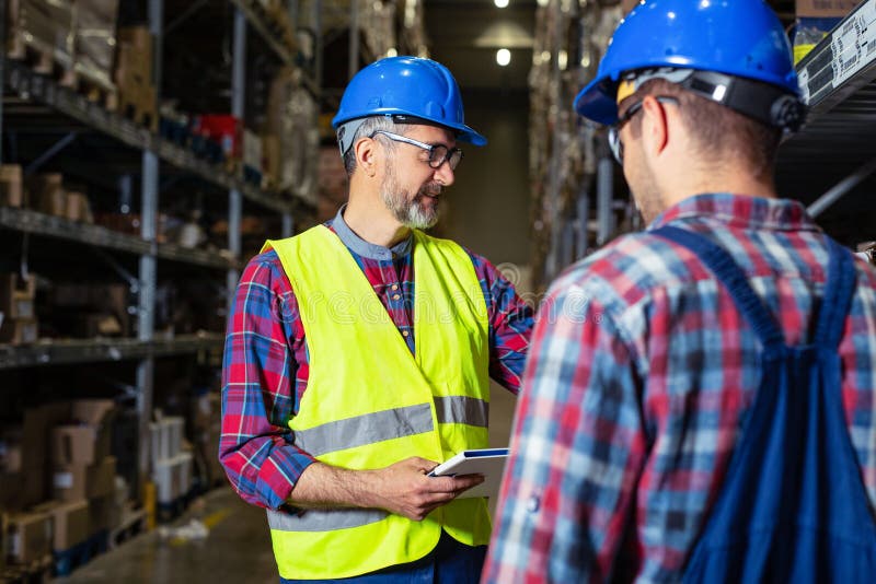 Working in warehouse, managers and workers checking inventory. stock photography