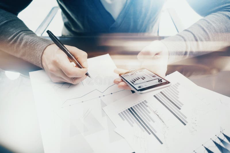 Working process. Account manager working at the table with new business project.Holding modern smartphone hand stock photography Working process. Account manager working at the table with new business project.Holding modern smartphone hand stock photography