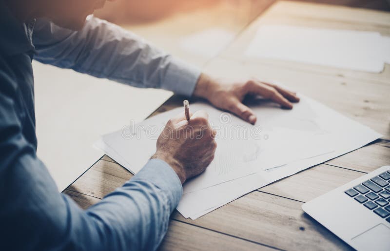 Working process. Businessman working at the wood table with new project. Generic design notebook on table. Horizontal stock photography
