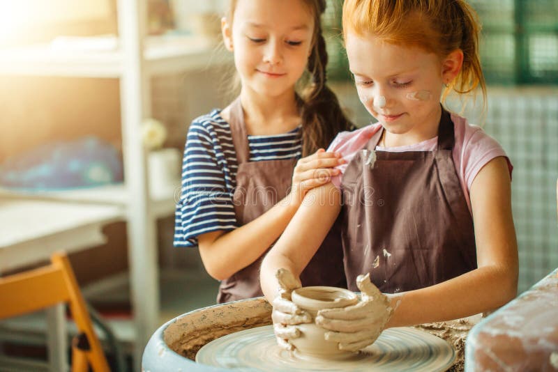 Working process with clay potter wheel. Two girls making pottery in studio royalty free stock photo Working process with clay potter wheel. Two girls making pottery in studio royalty free stock photo