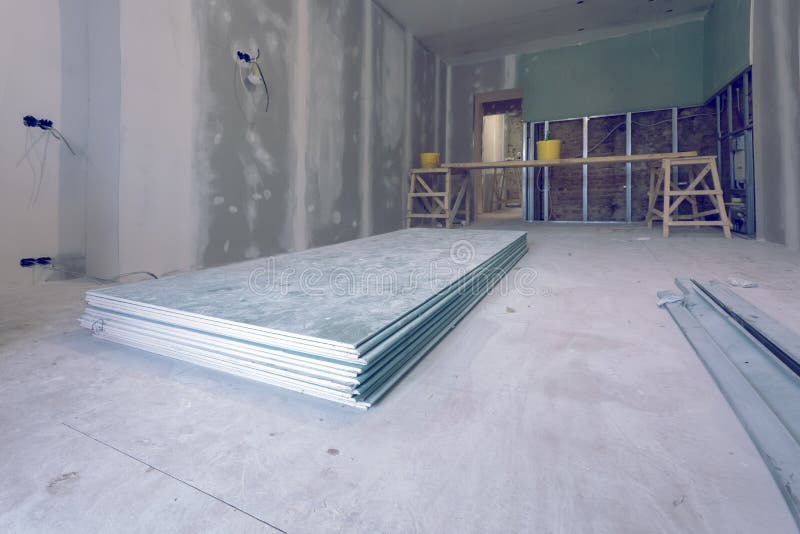 Working process of installing metal frames and plasterboard drywall and materials in apartment is under construction stock image