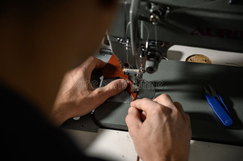 Working Process of Leather Craftsman. Tanner or Skinner Sews Leather on