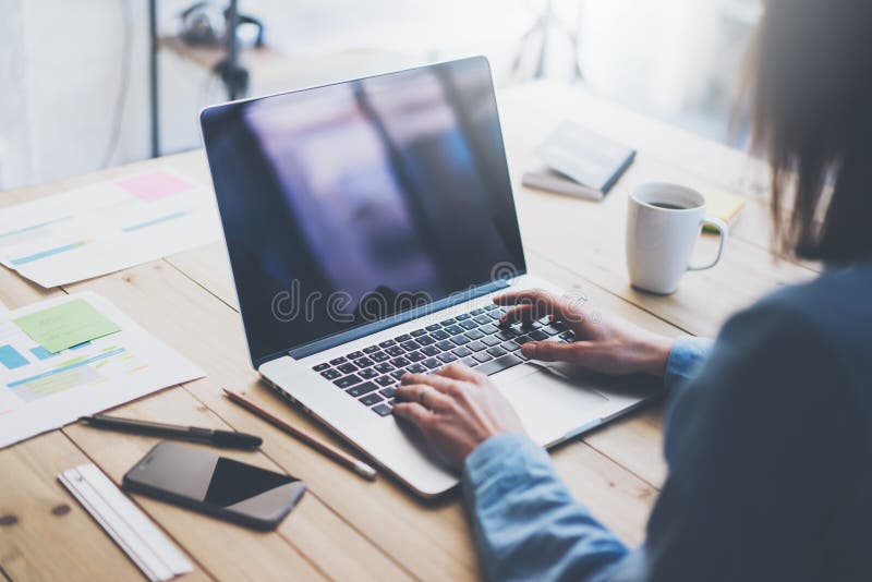 Working process photo.Woman working wood table with new business project.Typing contemporary laptop, reflections screen. Modern smartphone table.Horizontal stock photo Working process photo.Woman working wood table with new business project.Typing contemporary laptop, reflections screen. Modern smartphone table.Horizontal stock photo