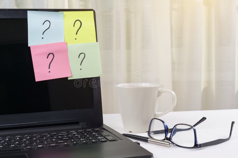 The working table of the freelancer. Stickers with question marks stick to the laptop. royalty free stock images