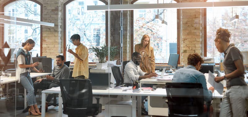 Group of young mixed race business people working together in the creative office. Team building concept. Office life. Cooperation. Group of young mixed race business people working together in the creative office. Team building concept. Office life. Cooperation