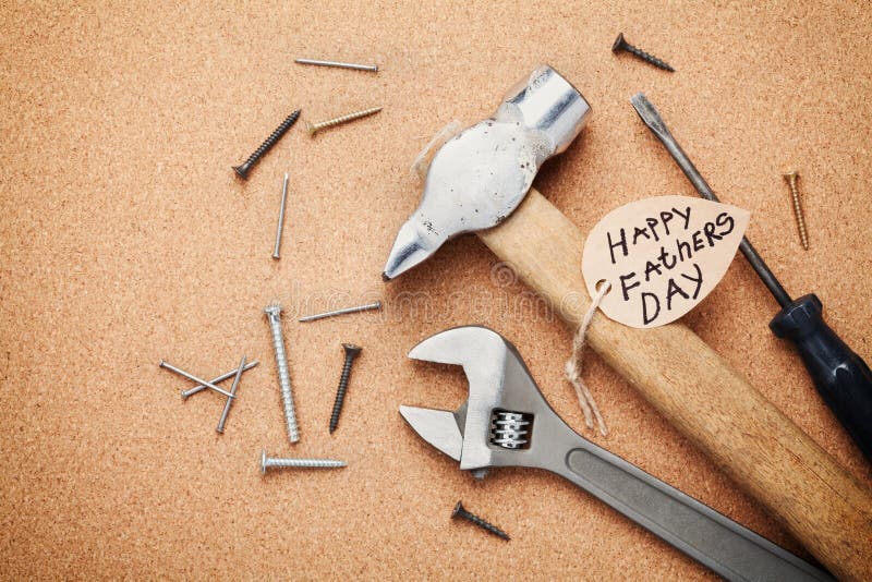 Working tools and note for Happy Fathers Day, cork board background, top view, flat lay