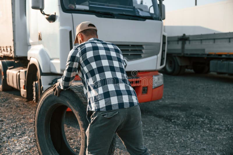 Working with Wheels. Young Truck Driver is with His Vehicle at Daytime
