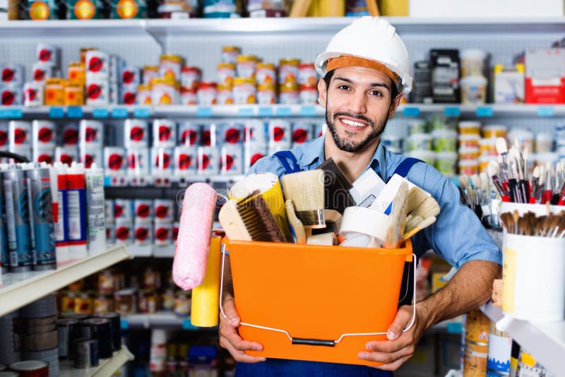 Workman Holding Basket with Picked Tools in Paint Store Stock Photo