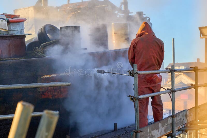 Workman Pressure Washing the Hull of a Boat Stock Photo Image of