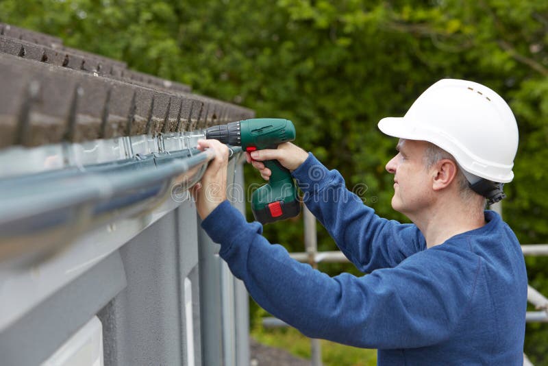 Workman Replacing Guttering On Exterior Of House royalty free stock images