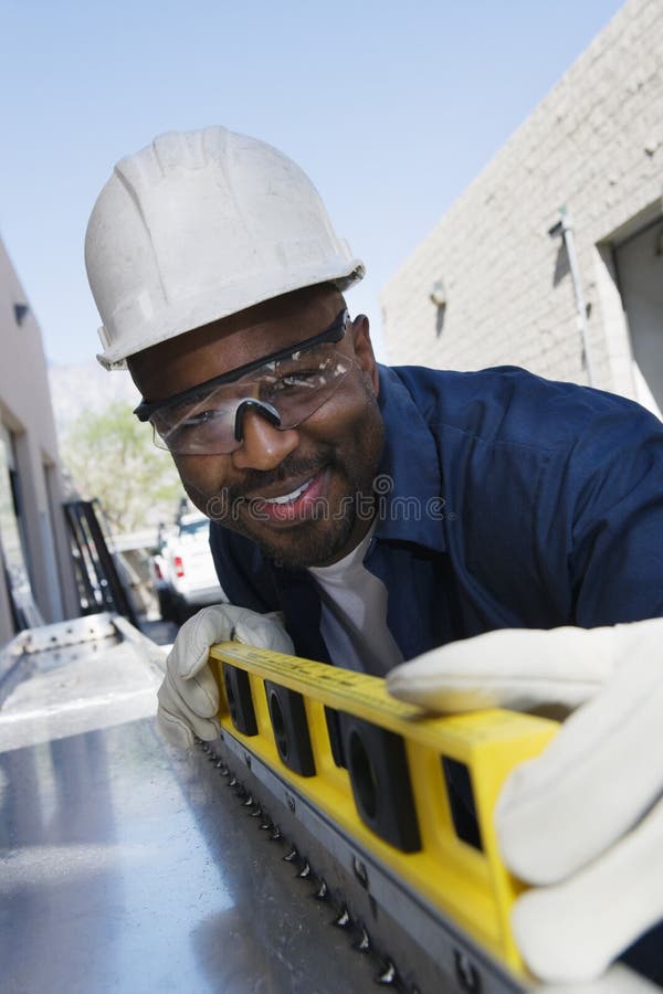 Happy workman using a yellow level. Happy workman using a yellow level