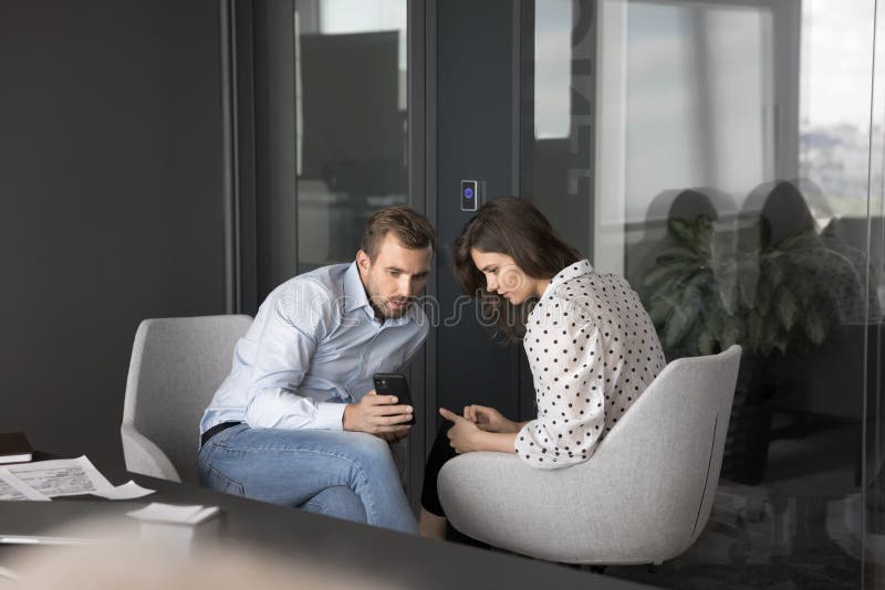 Workmates discuss new mobile application at workplace royalty free stock photography