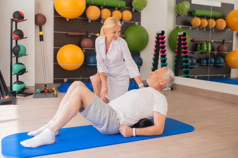 Physical Therapist in Lab Coat Working with a Patient Stock Image