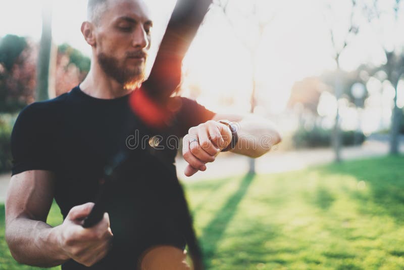 Workout smart lifestyle concept.Bearded muscular athlete doing great exercising TRX outside in summer park.Young royalty free stock photo Workout smart lifestyle concept.Bearded muscular athlete doing great exercising TRX outside in summer park.Young royalty free stock photo