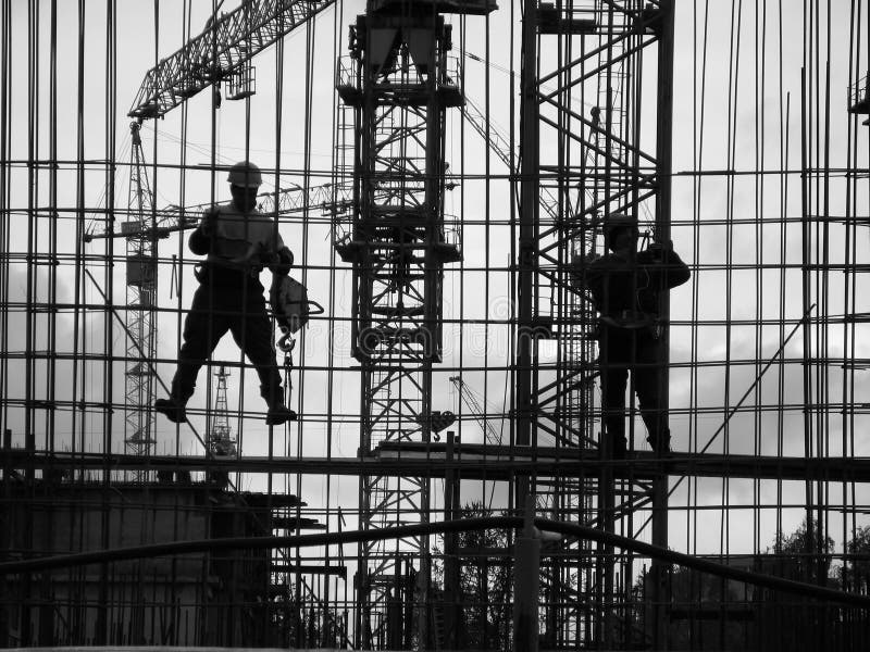 Construction site, evening, workers assemble the elements of the building structure. Construction site, evening, workers assemble the elements of the building structure.