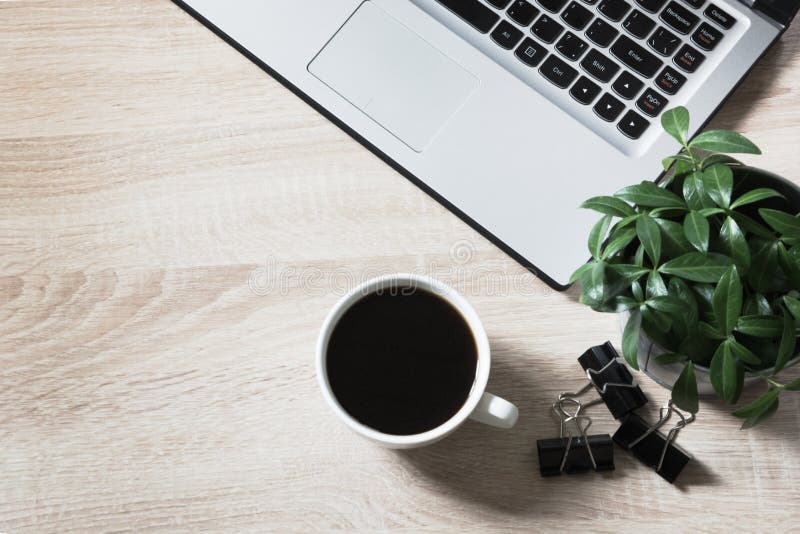 Workplace with open laptop and cup of coffee on office wooden desk table. Top view, copy space. stock photo Workplace with open laptop and cup of coffee on office wooden desk table. Top view, copy space. stock photo
