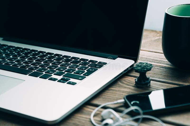 Workplace with open laptop on modern wooden desk royalty free stock photography