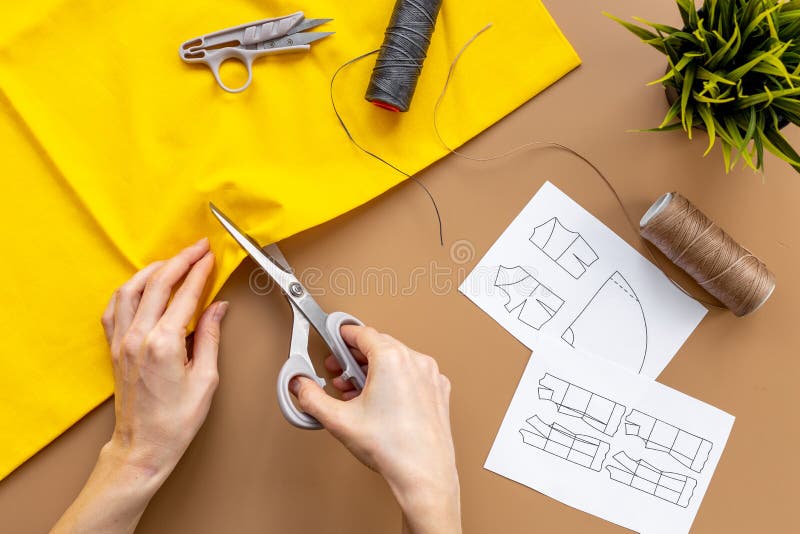 Workplace of Seamstress. Hands Doing Sewing Patterns with Fabric Stock
