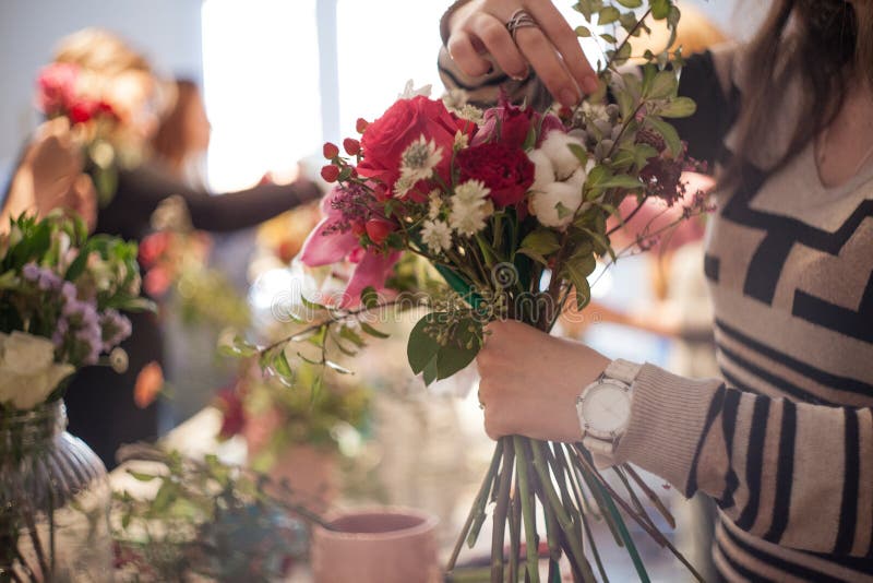 Workshop florist, making bouquets and flower arrangements. Woman collecting a bouquet. Soft focus