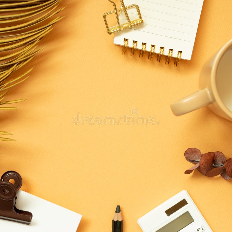 Workspace concept. Note, memo pad, clip, pencil, calculator, mug cup, plant on orange desk background. flat lay, top view, copy space. studio shot