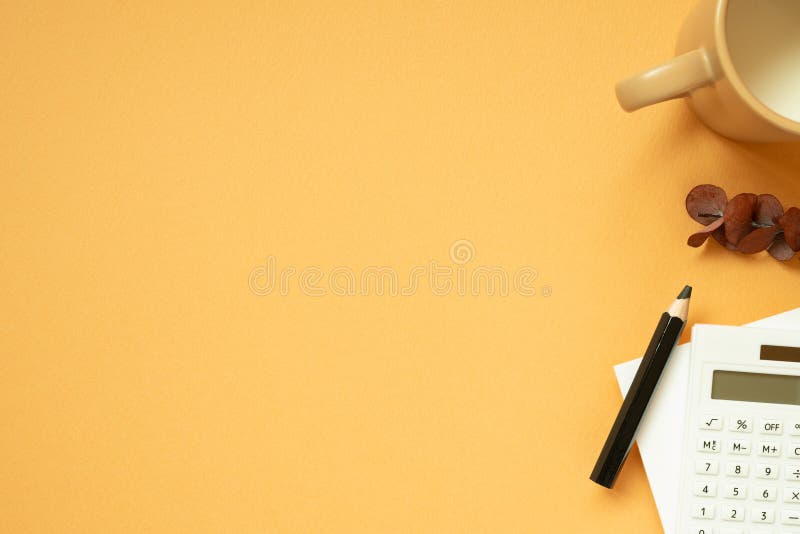 Workspace concept. Notepad, pencil, calculator, mug cup, plant on orange desk background. flat lay, top view, copy space. studio shot