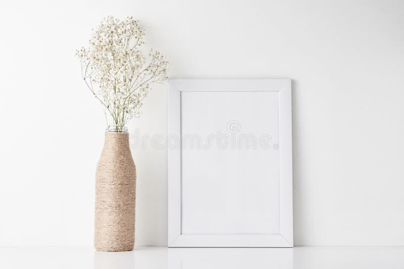 Workspace desk with empty frame and flower in vase stock image
