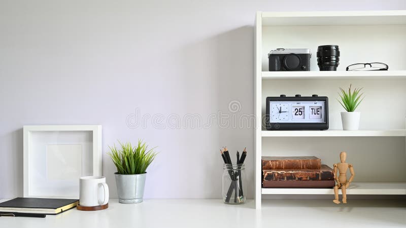 Workspace shelves with camera, lens with photo frame and coffee mug on table stock photos