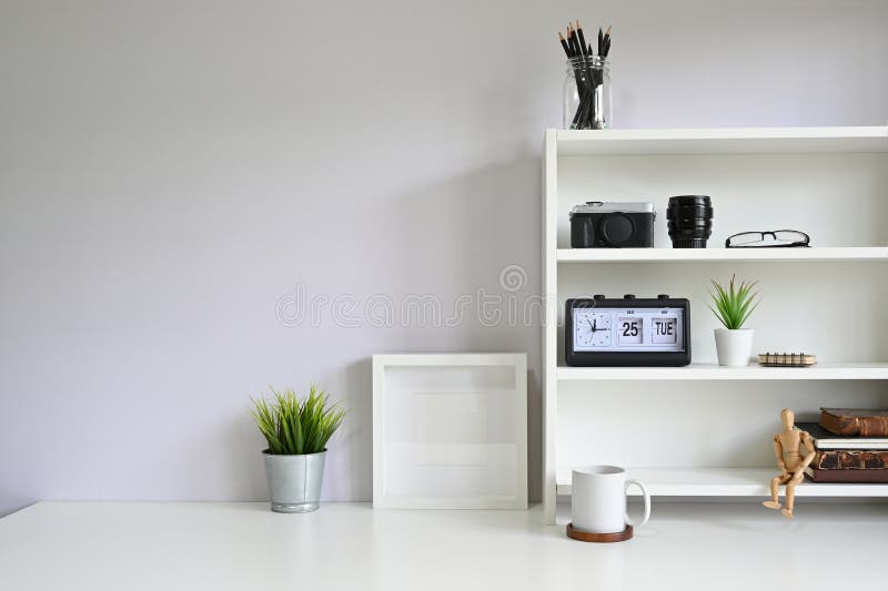 Workspace shelves with camera, lens with photo frame and coffee mug on table royalty free stock image